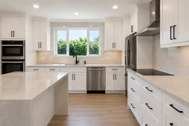 Single-family kitchen remodel with semi-custom cabinetry, quartz waterfall countertop, modern warm residential atmosphere, Miami-Dade County