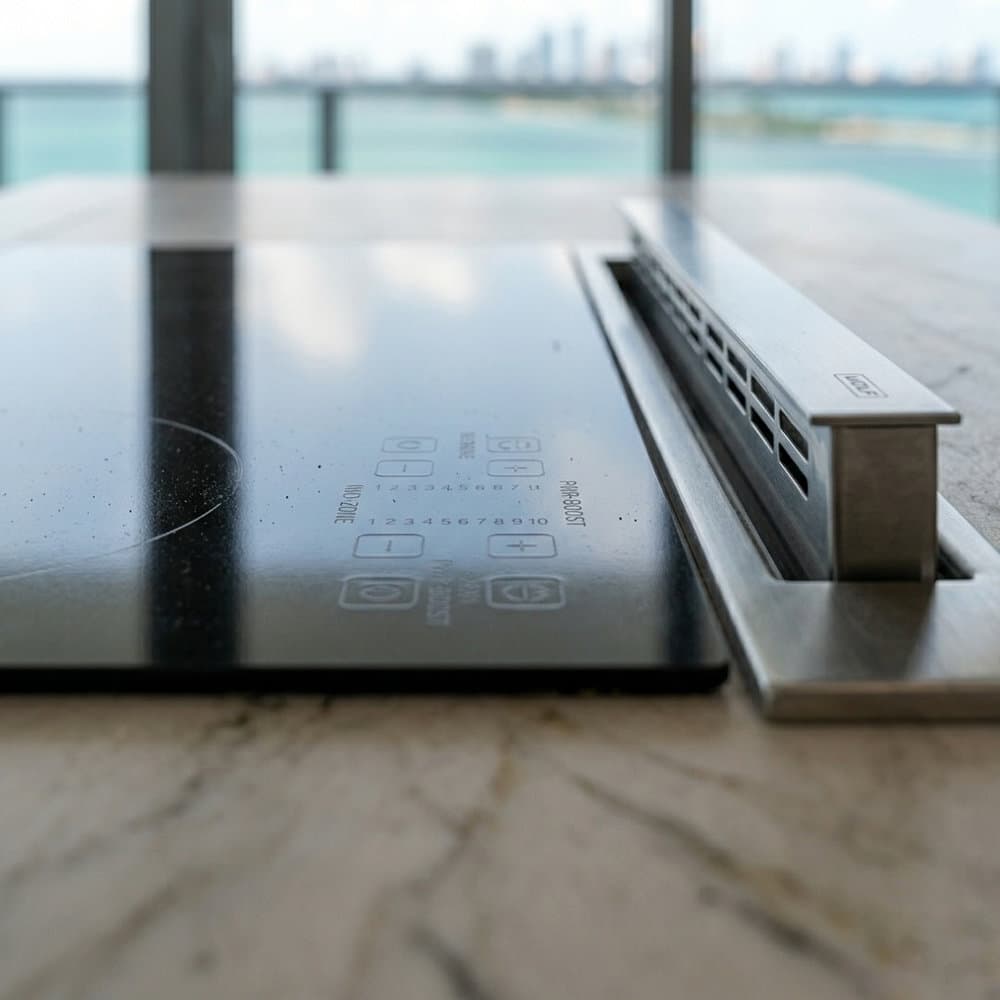 Completed coastal condo kitchen — induction range with downdraft ventilation