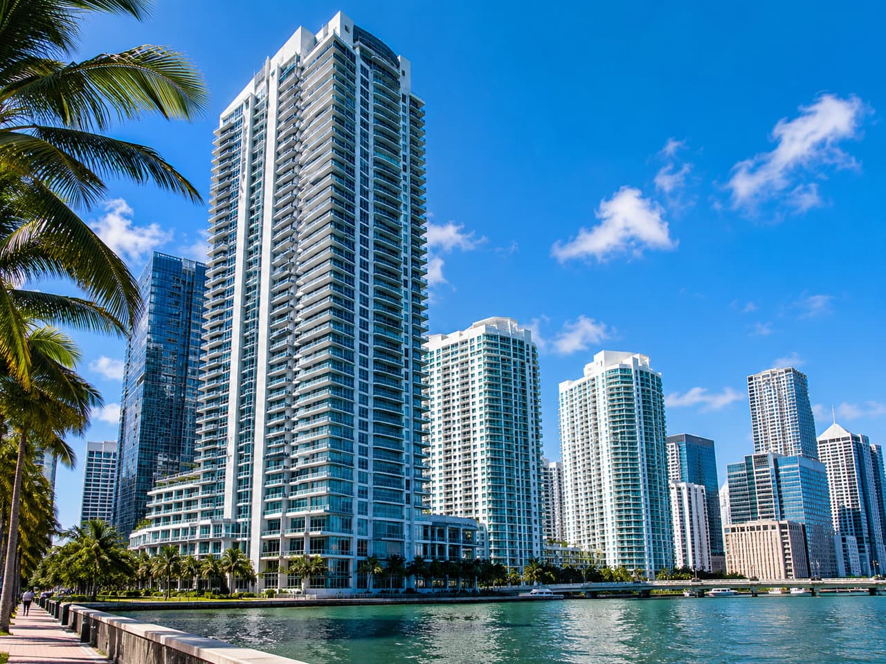 Brickell high-rise condo towers along Biscayne Bay with a palm-lined waterfront promenade