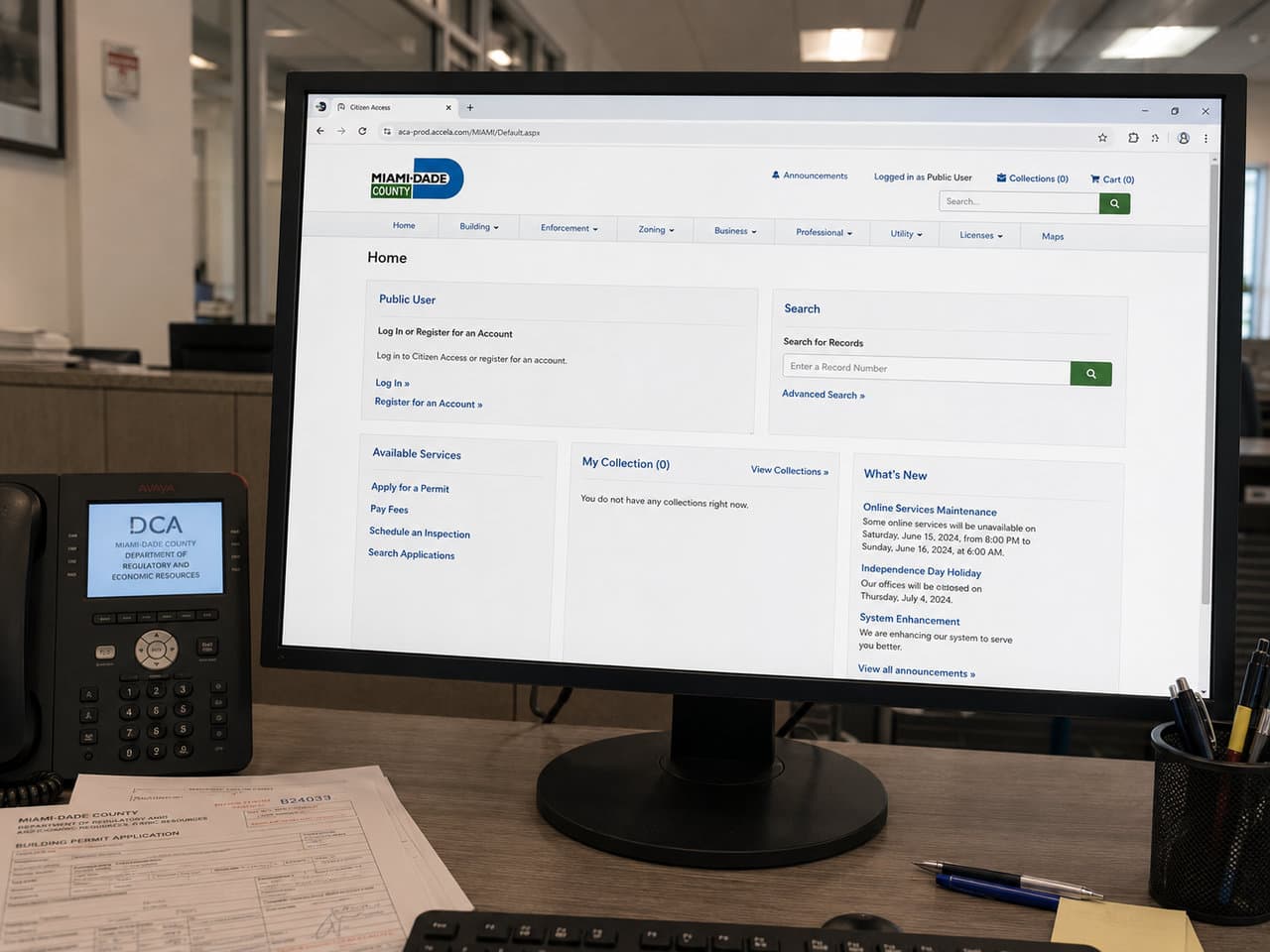 Miami-Dade Citizen Access permit portal open on an office monitor beside a paper permit application