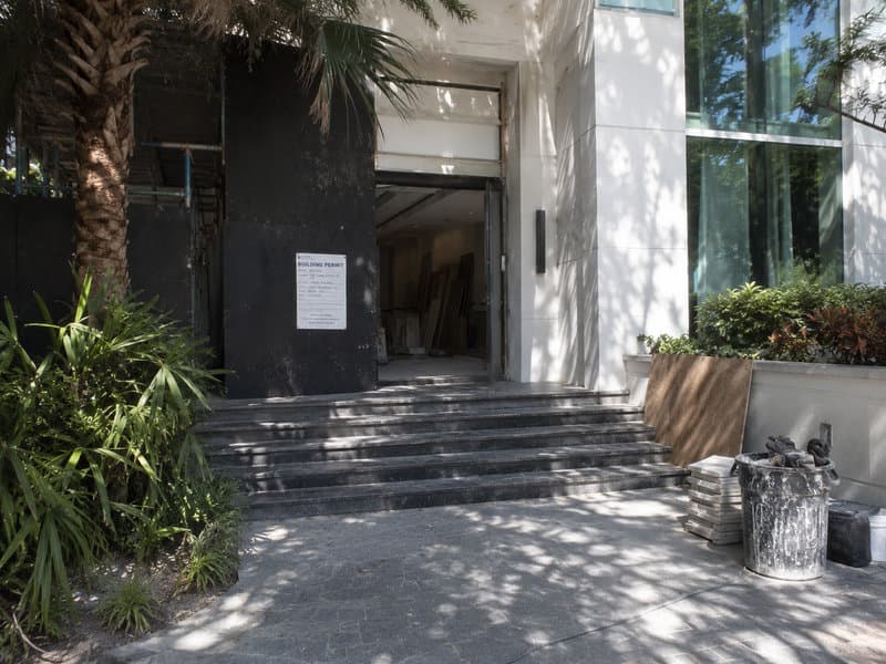 Active Aventura jobsite with posted permit card and licensed-contractor signage at the unit entry