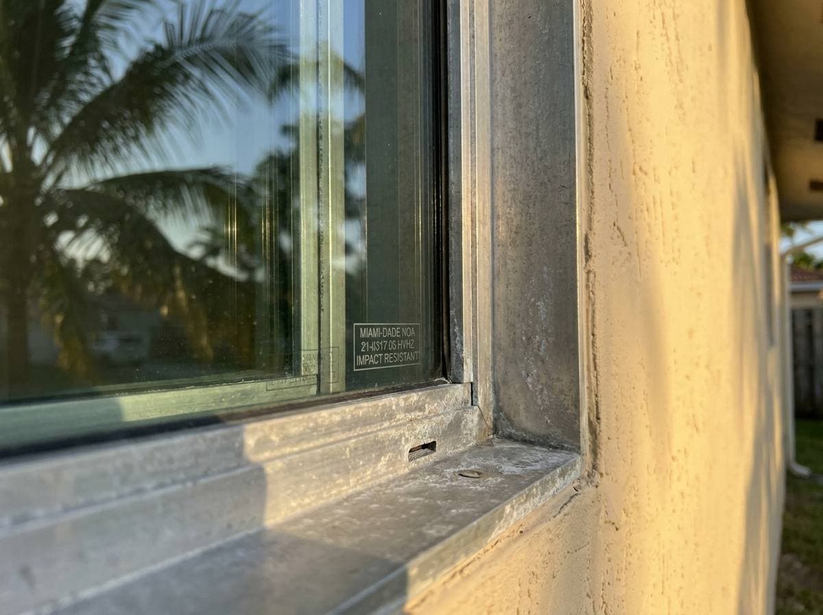 HVHZ-rated impact glass detail at exterior window flange, representative of Broward County envelope work governed by Florida Building Code 8th Edition