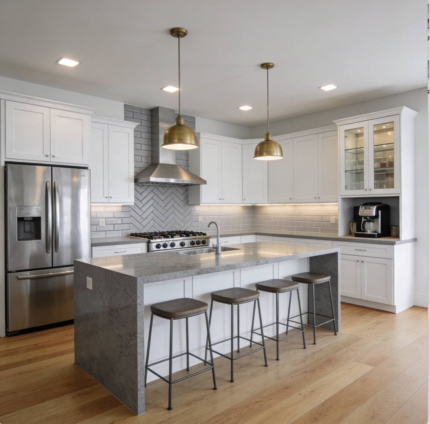 Completed kitchen remodel with two-tone dark and white cabinetry, a center island with pendant lighting, and stainless steel appliances