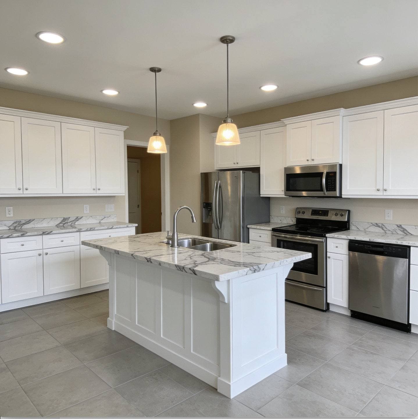 Completed kitchen remodel with white shaker cabinetry, a center island with pendant lighting, and stainless steel appliances