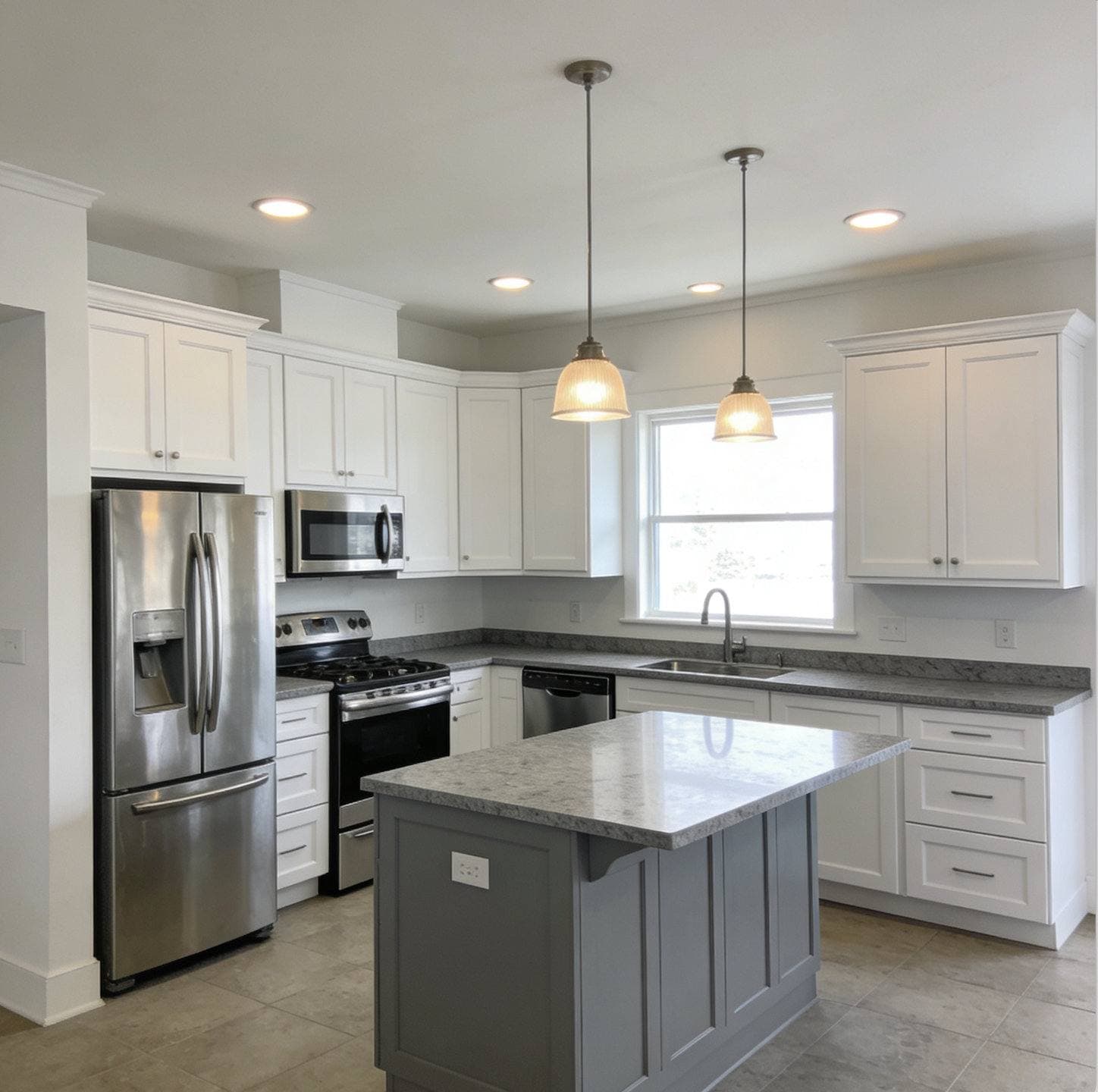 Completed kitchen remodel with white shaker cabinetry, a center island with pendant lighting, and stainless steel appliances