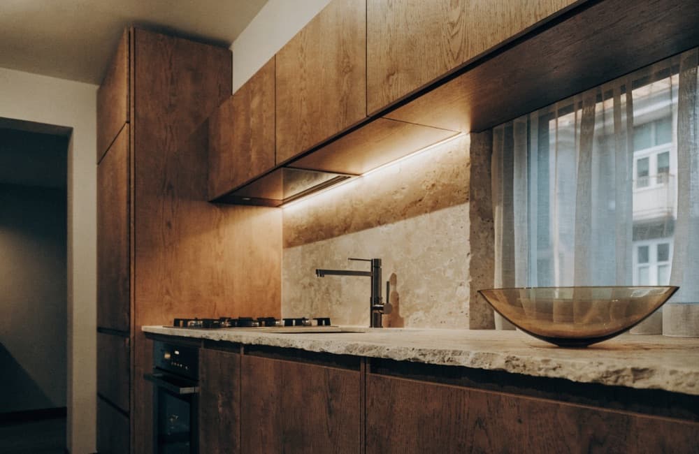 Completed Miami kitchen with full-height cabinetry, a stone island and pendant lighting over the counter.