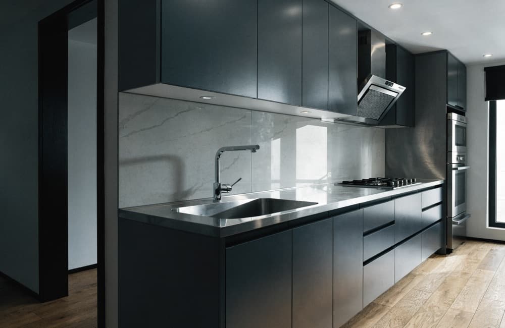 Finished kitchen interior with wood cabinetry, a tiled backsplash and an integrated cooktop.